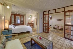 een slaapkamer met een bed en een woonkamer bij French Haveli in Ahmedabad