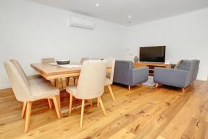 comedor con mesa de madera y sillas en Staughton Sounds en Capel Sound