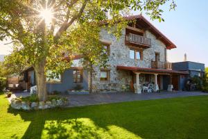 duży kamienny dom z drzewem w ogrodzie w obiekcie URAIN Suites - Apartments at Flysch-Coast w mieście Zumaia