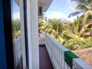 balcón con vistas a las palmeras en Vincent's Holiday Home, en Baga