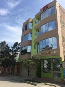 un edificio de color verde y marrón en Suites El Parque, en Lima