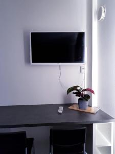 a desk with a tv on a wall with a plant at 57 Kauppakatu in Varkaus