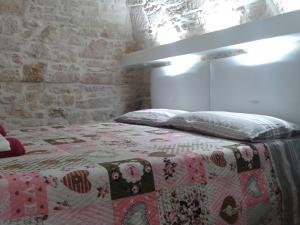 a bed with a quilt on it in a bedroom at Lilla B&B in Molfetta
