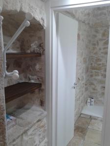 łazienka z kabiną prysznicową obok kamiennej ściany w obiekcie Lilla B&B w mieście Molfetta