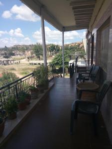 a porch with chairs and a view of a field at Padmaa Hampi Villa in Hampi