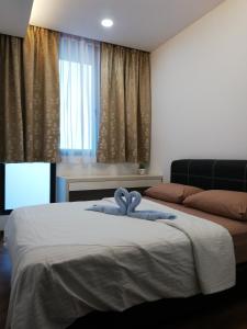 a bedroom with a bed with a blue ribbon on it at Vivacity jazz suite 3 condo 139 in Kuching