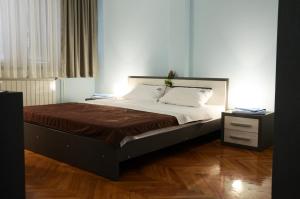 1 dormitorio con 1 cama grande y suelo de madera en Hotel MK, Plavi restoran, Loznica, en Loznica