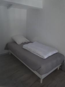 レ・ズィサンブルにあるhaut des issambres 13 - 3 pieces 2 chambres 4 personnesの白い壁のドミトリールームのベッド1台分です。