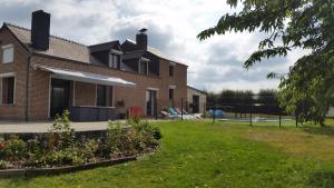 a large brick house with a grass yard at Le Clos de Ramousies in Ramousies