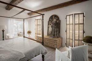 a bedroom with a bed and a table and chairs at L'Hôtel Particulier in Arles