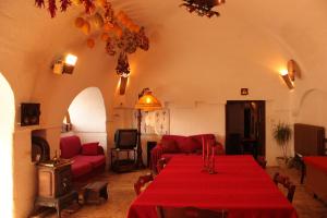 a living room with a table with a red table cloth at Masseria Sierro lo Greco in Laterza