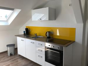 a small kitchen with a sink and a stove at Ferienwohnung Eimeldingen in Eimeldingen