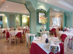 una sala da pranzo con tavoli e sedie con tovaglia rossa e bianca di magnifique maison en resort près des plages ad Albufeira