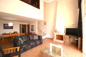 un soggiorno con divano e una sala da pranzo di magnifique maison en resort près des plages ad Albufeira
