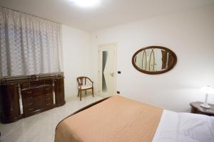 een slaapkamer met een bed, een spiegel en een stoel bij City Center n. Two in San Severo