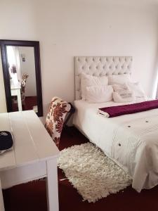 a bedroom with a white bed and a white desk at amazing grace guesthouse in East London