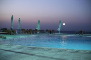 a large swimming pool with chairs and umbrellas at New Panorama Resort in Fayoum Center