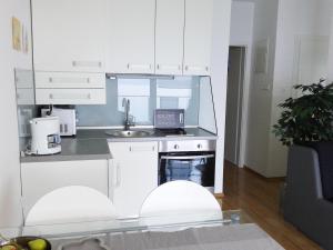 a white kitchen with white cabinets and a sink at Apartment Sol - 5m from the sea in Drasnice