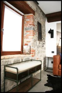 a bed in a room with a stone wall at Casa Vacanze Borc dai Cucs in Faedis