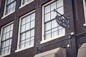 un panneau sur le côté d'un bâtiment en briques dans l'établissement Singel Hotel Amsterdam, à Amsterdam