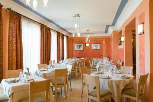 a dining room with white tables and chairs at Hotel Villa Mare in Altavilla Milicia