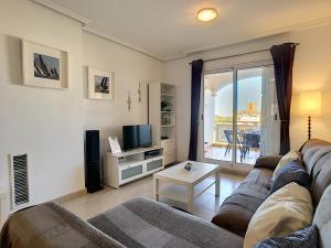 een woonkamer met een bank en een televisie bij Ribera Beach 3 - 1009 in Mar de Cristal