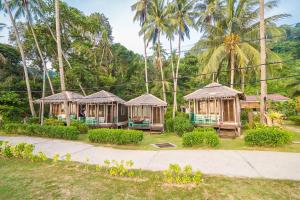 a row of gazebos in a park with palm trees at 1511 Coconut Grove in Tioman Island