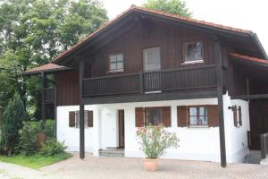 a house with a balcony on top of it at Ferienhaus Schusterhof in Bergen