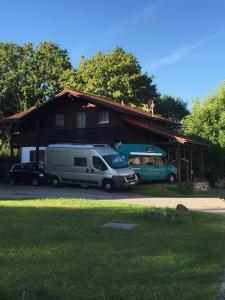 two rvs parked in front of a house at Ferienhaus Schusterhof in Bergen