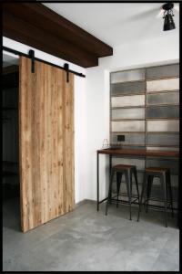 una puerta de madera en una habitación con mesa y taburetes en Casa Vacanze Borc dai Cucs, en Faedis