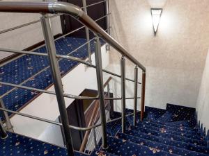 klatka schodowa w budynku z niebieskimi schodami w obiekcie ArcadiaSky w Odessie