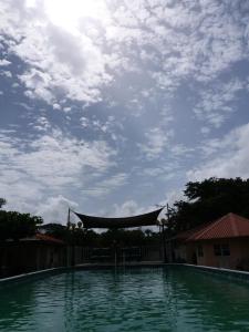 a large swimming pool with a cloudy sky in the background at Surinat Luxury Resort in Domburg