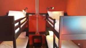2 beliches num quarto com paredes vermelhas em O Albergue em Lugo