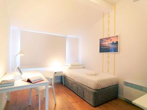 a bedroom with a bed and a desk with a laptop at Uporto House Villa in Porto