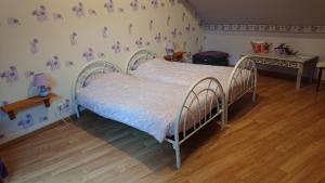 a bedroom with a bed and a wooden floor at Les Chambres du Relais in Liettres