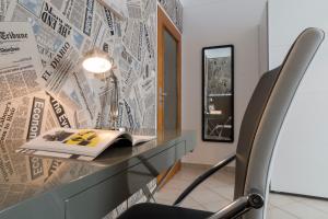 einen Schreibtisch mit einem Stuhl, einem Buch und einem Spiegel in der Unterkunft Villa Nakalua in Luxemburg (Stadt)