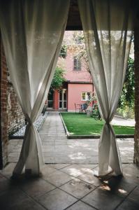 an open patio with curtains and a table in a yard at Garden Vittoria in Cremona