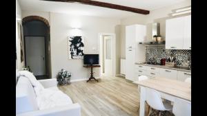 uma cozinha com armários brancos e uma mesa de madeira em Garden Vittoria em Cremona