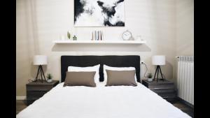a bedroom with a large white bed with two lamps at Garden Vittoria in Cremona