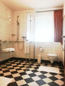 a bathroom with a glass shower and a toilet at Hotel Seemöwe in Simmerath