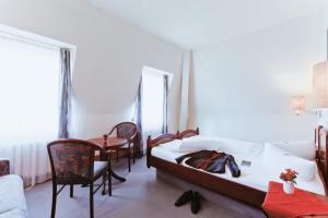 - une chambre avec un lit, une table et des chaises dans l'établissement Hotel Kipping, à Dresde
