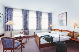 um quarto de hotel com uma cama, uma mesa e cadeiras em Hotel Kipping em Dresden