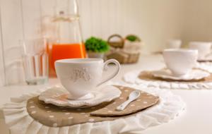 a table with two tea cups and saucers on it at il risveglio di alice in Fano +9 photos