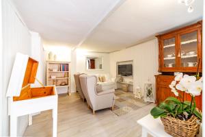 a living room with a couch a chair and a television at il risveglio di alice in Fano