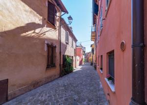 an empty street in an alley between two buildings at il risveglio di alice in Fano