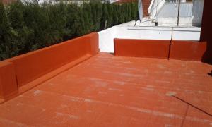 a balcony with an orange fence and a brick sidewalk at La casita de Miramar in Miramar