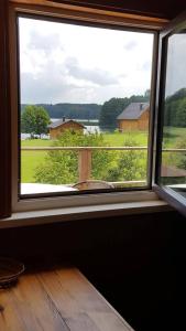 ein Fenster in einem Zimmer mit Blick auf ein Feld in der Unterkunft Nijolės sodyba in Aukštadvaris