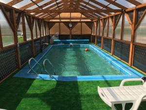 a swimming pool in a tent with a table and a chair at Villa Eden DeLux in Yanoshi