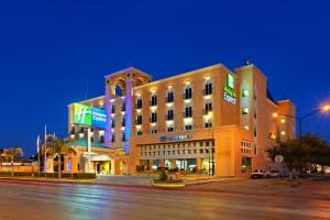 un gran edificio en una calle de la ciudad por la noche en Holiday Inn Express Torreon, an IHG Hotel en Torreón