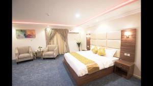 a hotel room with a bed and two chairs at Janan Al Nakheel Serviced Apartments in Al Muzāḩimīyah +32 photos